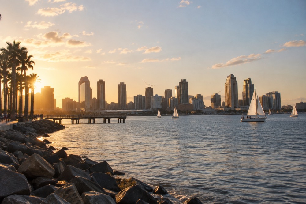 Golden late-afternoon light over San Diego Bay with sailboats near downtown