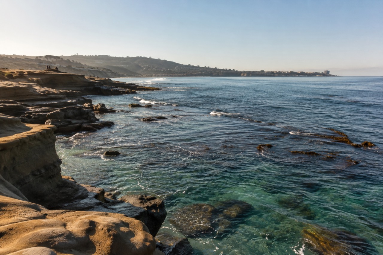 Clear turquoise water over a rocky reef with kelp along a sheltered coastline
