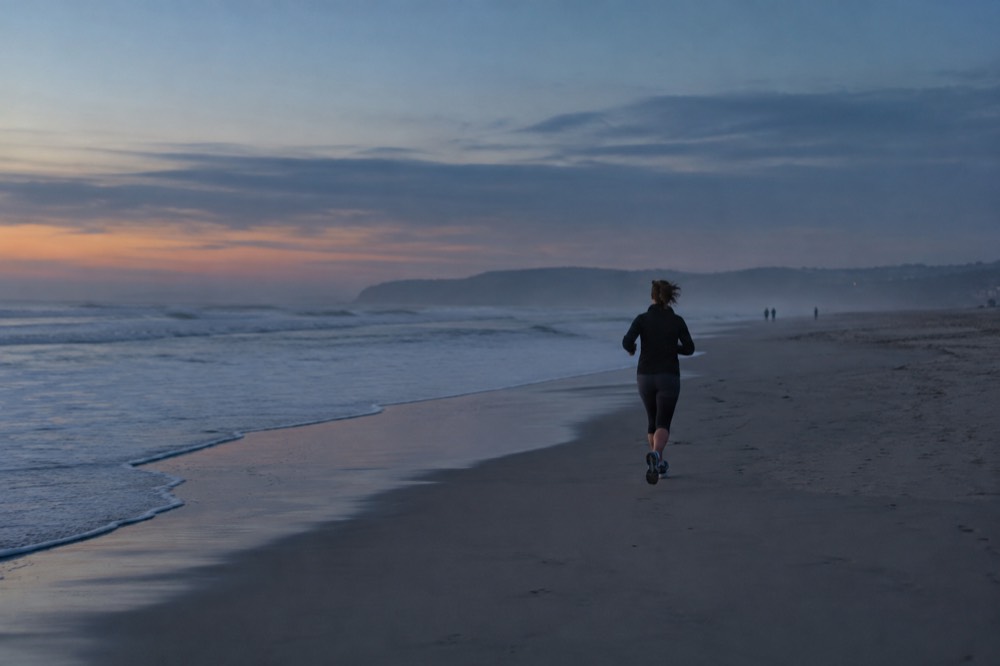 Wide empty Coronado Beach with gentle waves and morning haze