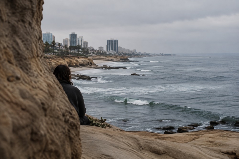 A rocky ocean overlook above kelp beds with waves rolling toward the horizon