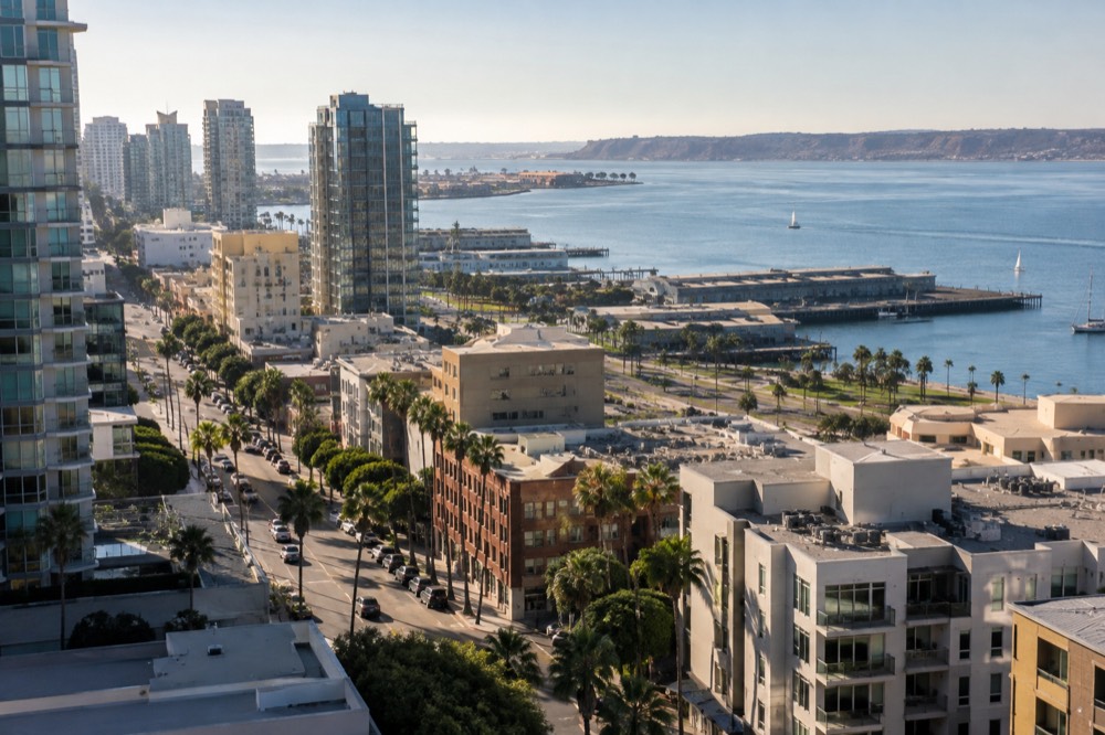 Sunlit San Diego coastline with calm blue water and cliffs in late afternoon light