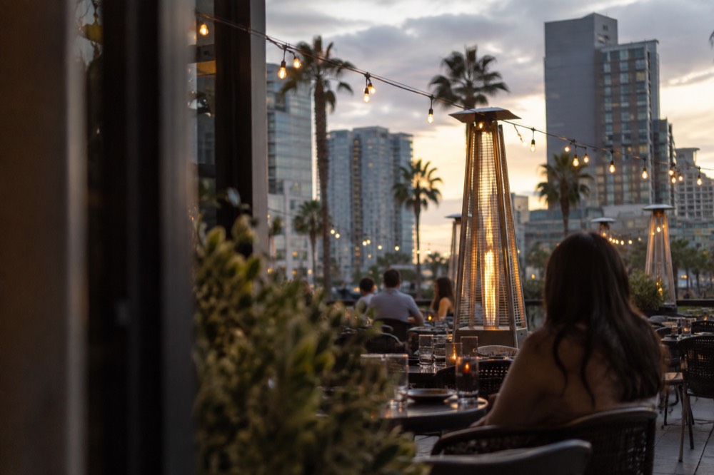 Outdoor restaurant patio with string lights in a historic downtown district at dusk
