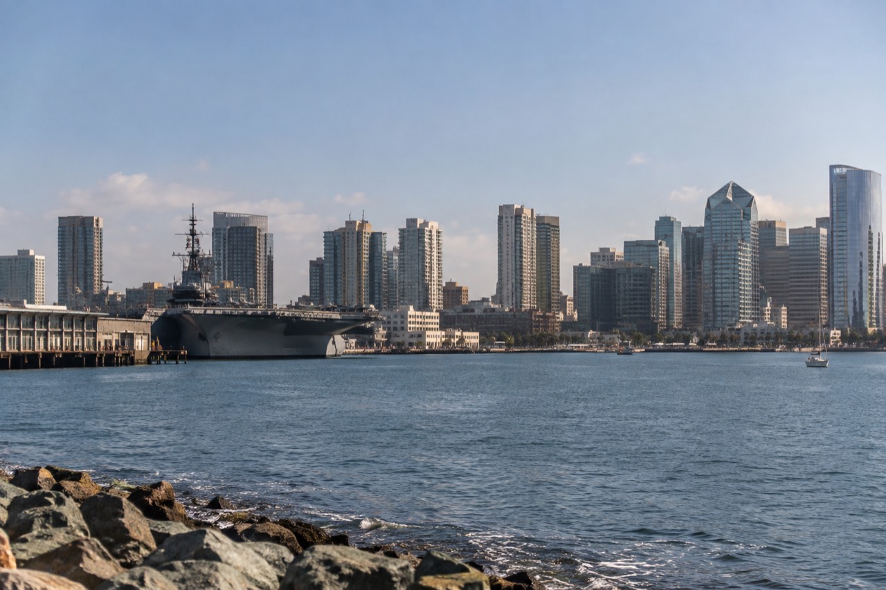 View over San Diego waterfront with the bay, downtown skyline and a museum ship at dock on a clear afternoon