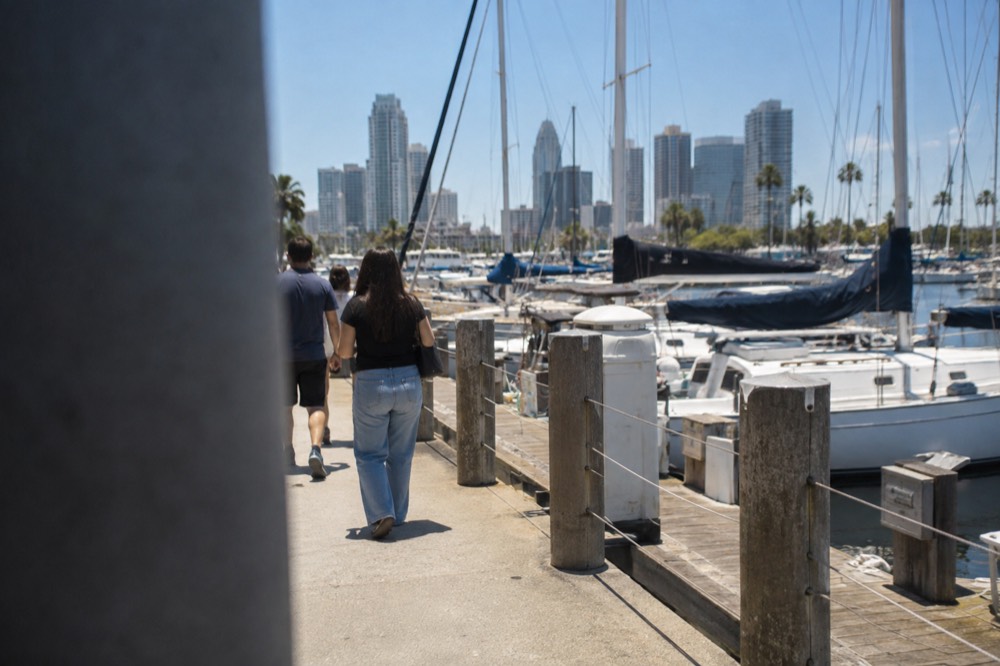 Waterfront promenade with sailboats moored along a wooden pier