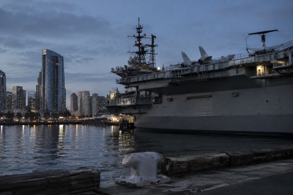 Flight deck of the USS Midway aircraft carrier with downtown San Diego behind it