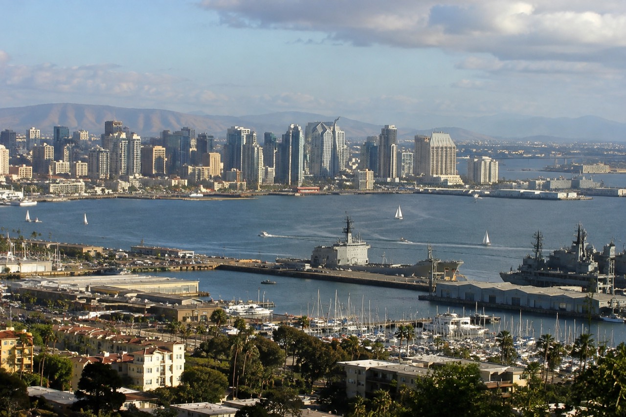 Aerial view of the San Diego waterfront with the bay, ships and city skyline in afternoon light