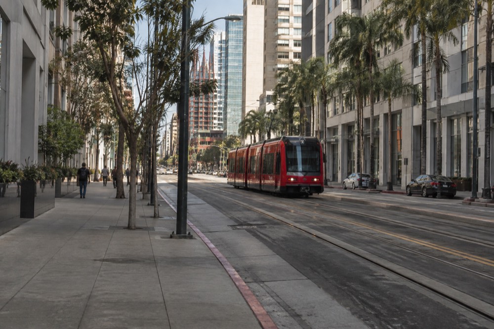 Downtown San Diego street with trolley tracks and buildings in sunlight
